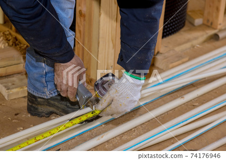 Worker cutting to measure cpvc pipe Worker cutting to measure cpvc pipe 74176946