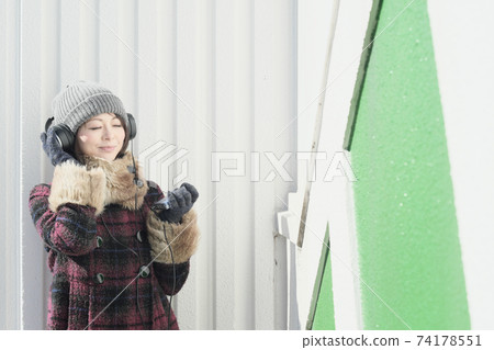 Woman listening to music on a portable cassette player Woman listening to music on a portable cassette player 74178551