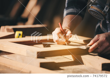 Confident wood worker expert. Young man working at factory. Skilled carpenter 74179572