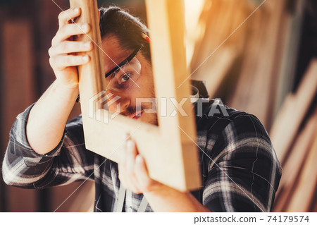 Confident wood worker expert. Young man working at factory. Skilled carpenter 74179574