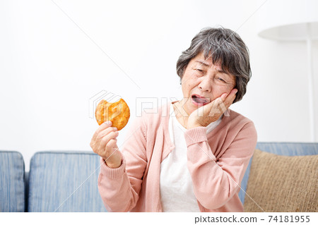 Senior woman eating rice crackers Senior woman eating rice crackers 74181955