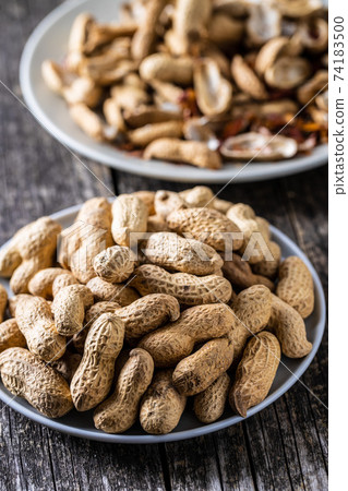Roasted peanuts. Tasty groundnuts on plate. 74183500