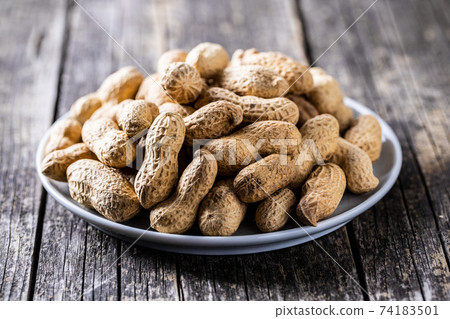 Roasted peanuts. Tasty groundnuts on plate. 74183501