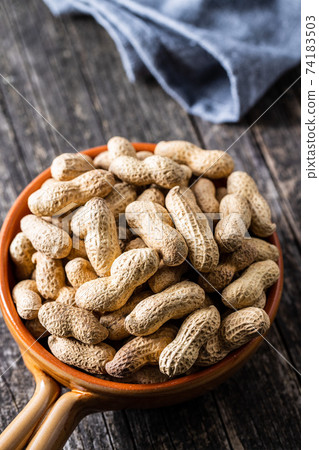 Roasted peanuts. Tasty groundnuts in pot. 74183503