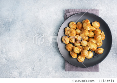 Traditional fried pelmeni, ravioli, dumplings filled with meat on black plate, russian kitchen. Gray concrete background, copy space. Traditional fried pelmeni, ravioli, dumplings filled with meat on black plate, russian kitchen. Gray concrete background, copy space. 74183614