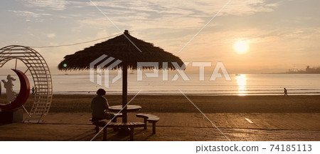 Back view of a woman watching the sunrise at Yeongildae Beach, Pohang, Korea 74185113