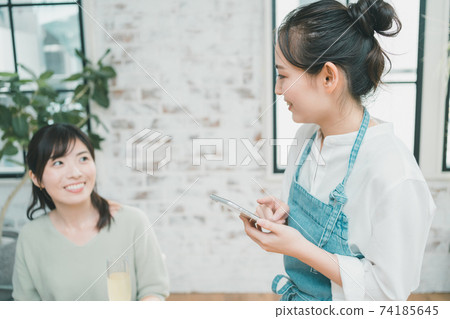在智能手機上接單的餐廳的女員工 74185645