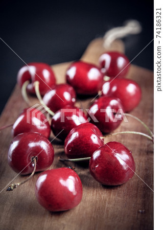 Fresh cherries on a wooden cutting board 74186321