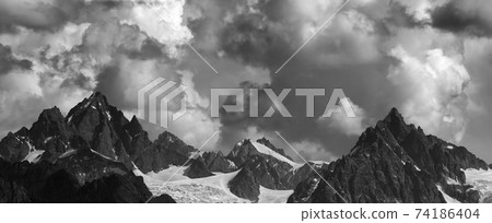 Panoramic view on high mountains with glacier and cloudy sky at summer day Panoramic view on high mountains with glacier and cloudy sky at summer day 74186404