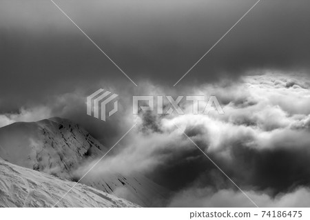 Off-piste slope and snowy rocks in bad weather before snow blizzard 74186475
