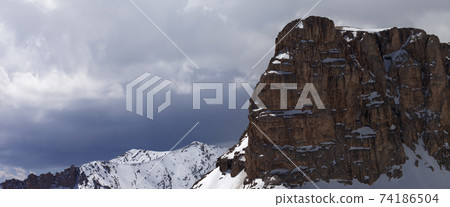 Snowy rocks and cloudy sky Snowy rocks and cloudy sky 74186504