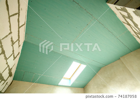 Interior of an apartment room with bare walls and ceiling under construction. 74187058