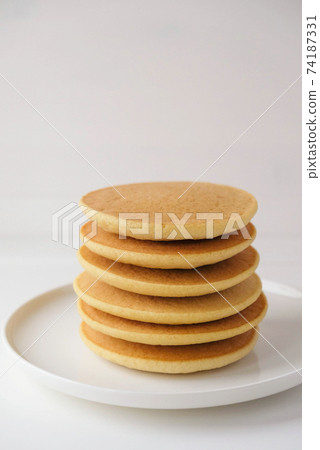 Freshly cooked soft delicious gluten free pancakes stacked on white plate. 74187331