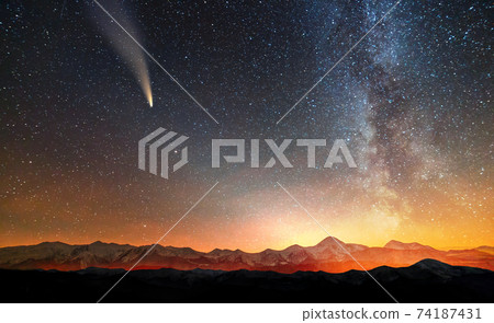 Surreal view of night in mountains with starry dark blue cloudy sky. Surreal view of night in mountains with starry dark blue cloudy sky. 74187431