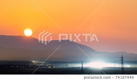 Beautiful sunset in mountains with Neowise comet with light tail in dark evening sunset sky. Beautiful sunset in mountains with Neowise comet with light tail in dark evening sunset sky. 74187449