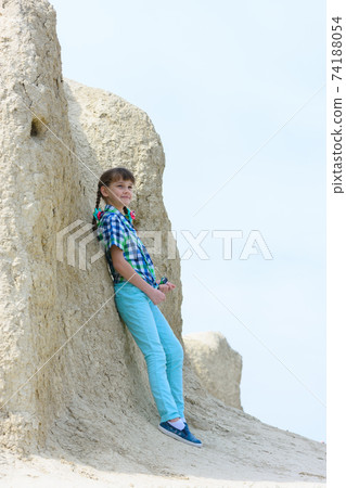 Ten year old girl pressed her back against a rock 74188054