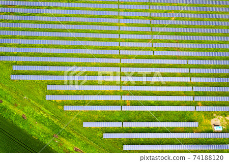 Aerial view of solar power plant on green field. Electric panels for producing clean ecologic energy. 74188120