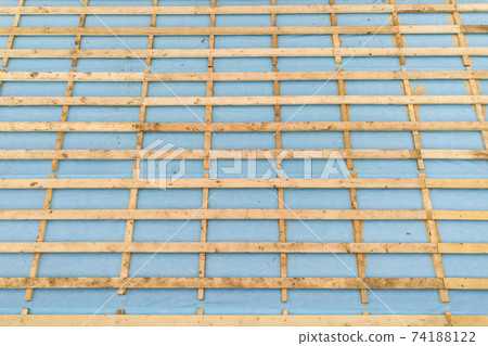 Aerial view of a brick house with wooden roof frame under construction. Aerial view of a brick house with wooden roof frame under construction. 74188122