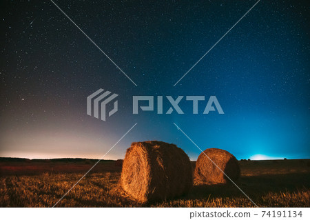 Comet Neowise C2020 F3 In Night Starry Sky Above Haystacks In Summer Agricultural Field. Night Stars Above Rural Landscape With Hay Bales After Harvest 74191134