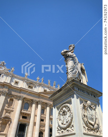 Statue of St. Peter in front of St. Peter's Basilica standing under the blue sky Statue of St. Peter in front of St. Peter's Basilica standing under the blue sky 74192973