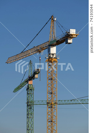 Three cranes in the evening light on a large construction site in the west of the Netherlands. Three cranes in the evening light on a large construction site in the west of the Netherlands. 74193044