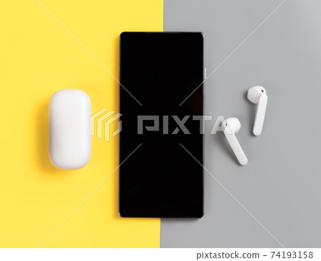 Smartphone and white wireless earphones Smartphone and white wireless earphones 74193158
