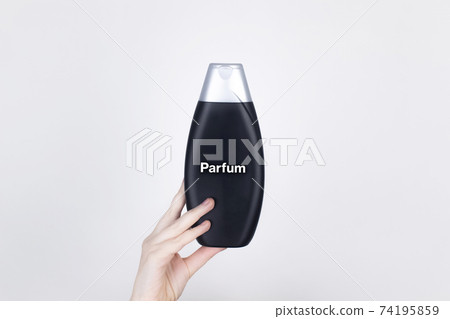 Chemical components on the shampoo label: Parfum. Female hands hold the jar on which indicates the harmful ingredient. White background, place for your text Chemical components on the shampoo label: Parfum. Female hands hold the jar on which indicates the harmful ingredient. White background, place for your text 74195859