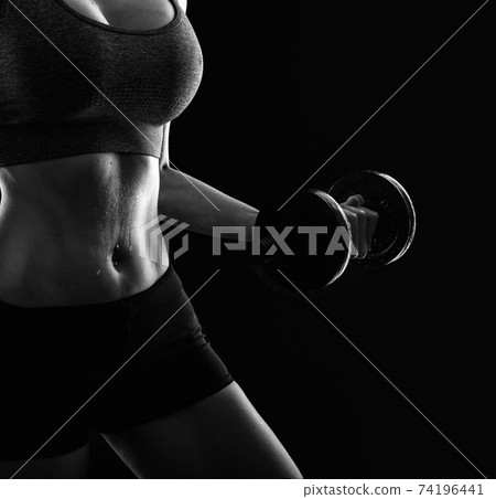 Slim athletic woman Holding dumbbell in the hand Slim athletic woman Holding dumbbell in the hand 74196441