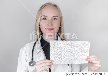 A neurologist examines an encephalogram of a patient brain. Schedule of electroencephalograms study of brain currents for signs of epilepsy and pathologies of the nervous system 74197034