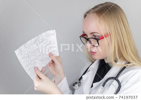 A neurologist examines an encephalogram of a patient brain. Schedule of electroencephalograms study of brain currents for signs of epilepsy and pathologies of the nervous system A neurologist examines an encephalogram of a patient brain. Schedule of electroencephalograms study of brain currents for signs of epilepsy and pathologies of the nervous system 74197037