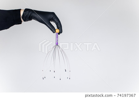 Close-up of capillary head massager isolated on white background. Manual device for home and professional massage Close-up of capillary head massager isolated on white background. Manual device for home and professional massage 74197367