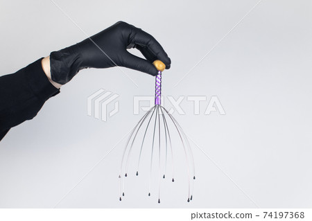 Close-up of capillary head massager isolated on white background. Manual device for home and professional massage Close-up of capillary head massager isolated on white background. Manual device for home and professional massage 74197368