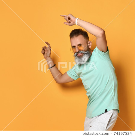 Positive smiling bearded man dancing studio shot Positive smiling bearded man dancing studio shot 74197524