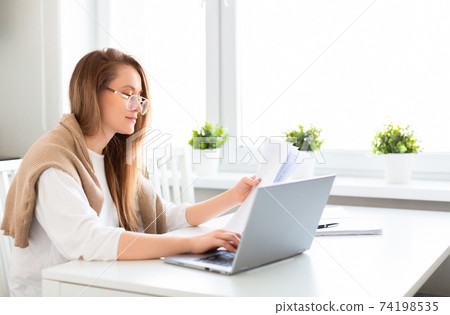 Woman works at home. Photo during an online consultation with a tax agent. 74198535
