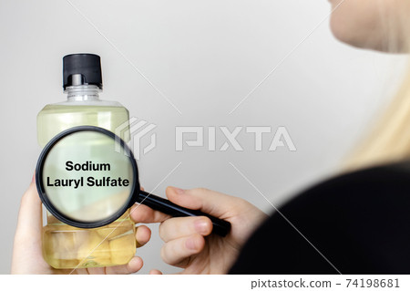A woman examines the harmful ingredients of the mouthwash. Harmful composition of ingredients. Rinse aid with Sodium Lauryl Sulfate A woman examines the harmful ingredients of the mouthwash. Harmful composition of ingredients. Rinse aid with Sodium Lauryl Sulfate 74198681