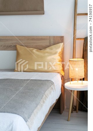 There is a golden silk pillow on the bed. There is a golden silk pillow on the bed. 74198957