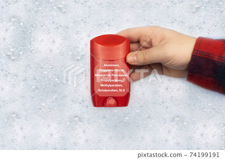 Antiperspirant floating in soapy water. Harmful composition of ingredients. Dry stick deodorant stick with Aluminum. The concept of hazardous substances in cosmetics and household chemicals 74199191