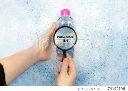 A bottle of micellar water floating in soapy water. Harmful composition of ingredients. Cleanser with Poloxamer 184. The concept of hazardous substances in cosmetics and household chemicals 74199196