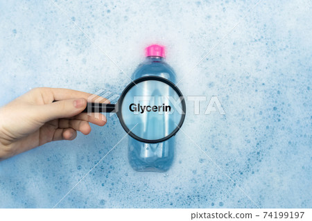 A bottle of micellar water floating in soapy water. Harmful composition of ingredients. Cleanser with glycerin. The concept of hazardous substances in cosmetics and household chemicals 74199197