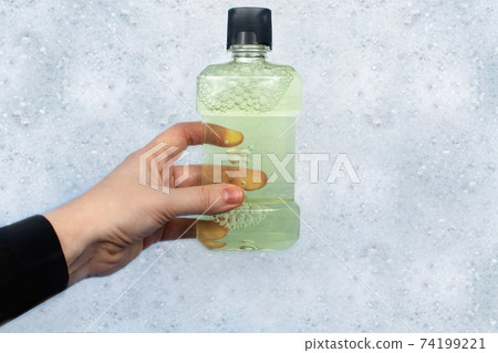 Detergent bottles float in the foam. The concept of the dangers of household chemicals. Laureate of sodium, parabens, sulfates and other chemical compounds in the composition. Mouthwash in a container Detergent bottles float in the foam. The concept of the dangers of household chemicals. Laureate of sodium, parabens, sulfates and other chemical compounds in the composition. Mouthwash in a container 74199221