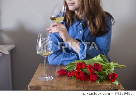 Lisbian girl, with a bouquet of flowers and a glass of wine in natural soft lighting. The concept of Lisbian girl, with a bouquet of flowers and a glass of wine in natural soft lighting. The concept of 74199493