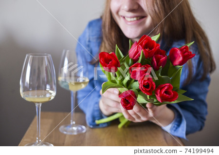 Lisbian girl, with a bouquet of flowers and a glass of wine in natural soft lighting. The concept of Lisbian girl, with a bouquet of flowers and a glass of wine in natural soft lighting. The concept of 74199494