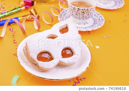 Cookies with powdered sugar in the form of a carnival mask and espresso on a yellow background Cookies with powdered sugar in the form of a carnival mask and espresso on a yellow background 74199818