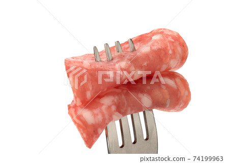 Close-up of two rolled-up pieces of cooked smoked sausage on a fork. Close-up of two rolled-up pieces of cooked smoked sausage on a fork. 74199963