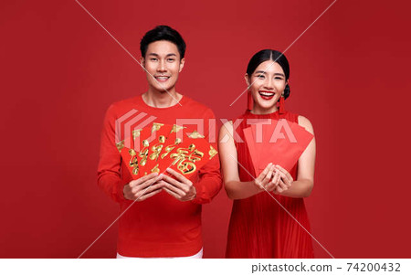 Happy asian couple in red casual attire with holding angpao or red packet monetary of happy new year Happy asian couple in red casual attire with holding angpao or red packet monetary of happy new year 74200432