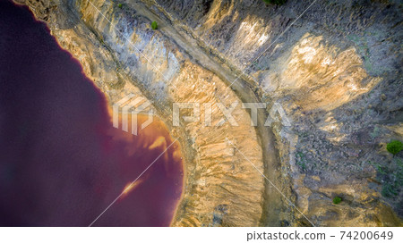 Red acidic lake in Mitsero, Cyprus aerial view detail 74200649
