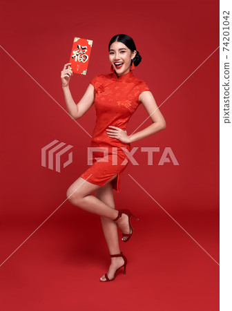 Asian woman wearing traditional cheongsam qipao dress holding angpao or red packet monetary gift Asian woman wearing traditional cheongsam qipao dress holding angpao or red packet monetary gift 74201042