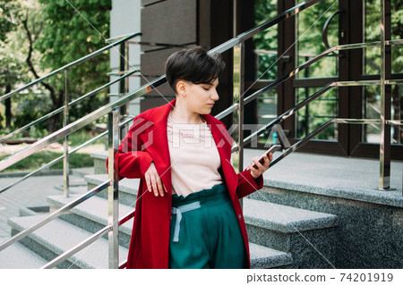 Gen z, social media, influencer, technology, youth millennial people concept. Young brunette girl with short hair using mobile phone outdoor 74201919