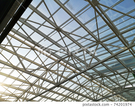Glass roof shopping center or airport. Architecture and design of the roof in the style of high-tech. The sun shines skok glass 74201974