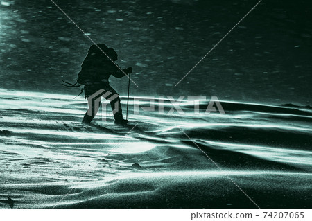 Climber fights with bad weather in the winter mountains, horror 74207065